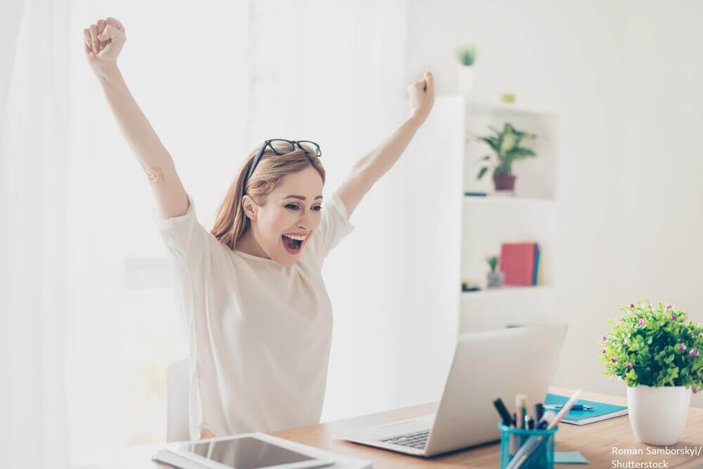 Girl celebrating victory on her computer